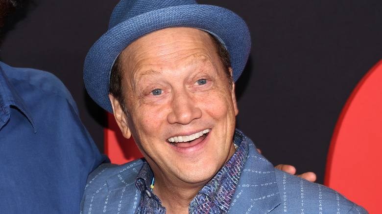 Rob Schneider souriant avec un chapeau