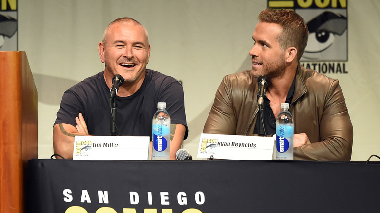 Tim Miller portant un t-shirt noir et Ryan Reynolds portant une veste en cuir marron