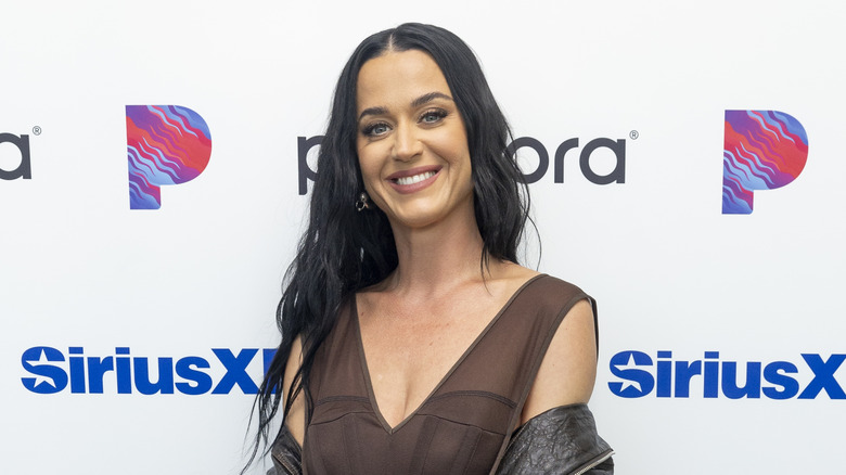 Katy Perry porte un chemisier transparent marron et une veste en cuir noir