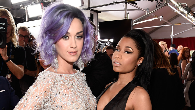 Katy Perry porte une robe scintillante argentée et Nicki Minaj porte une robe licou noire