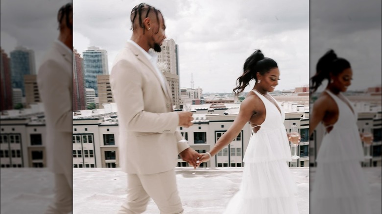 Jonathan Owens in a tan and white tuxedo and Simone Biles in a white wedding dress