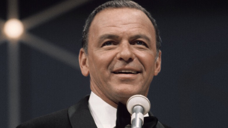 Frank Sinatra souriant en smoking sur scène