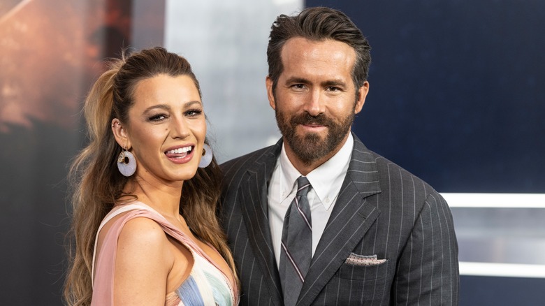 Blake Lively porte une robe multicolore avec Ryan Reynolds portant un costume à rayures grises et une cravate