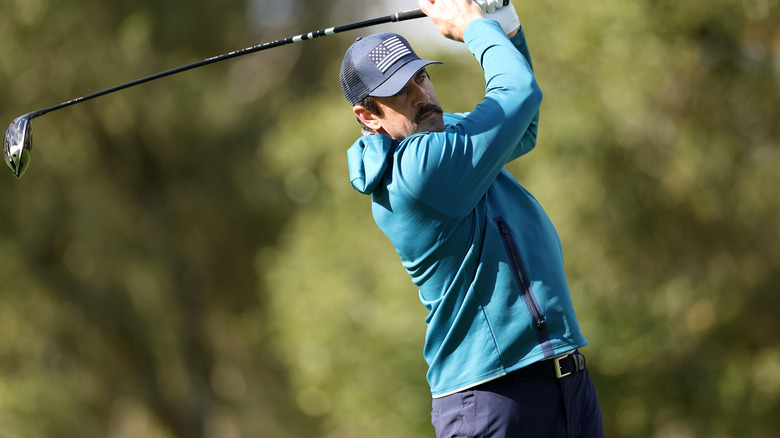 Aaron Rodgers balance un club sur un parcours de golf