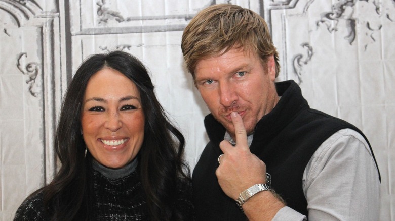 Joanna Gaines souriante, Chip Gaines avec le doigt sur les lèvres