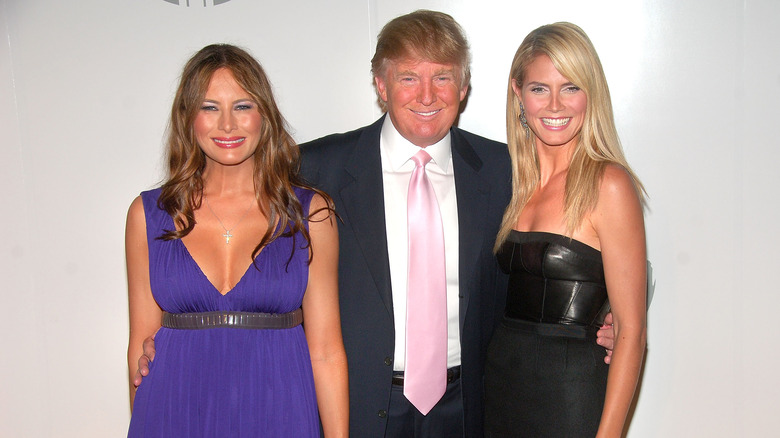 Donald Trump debout entre Melania Trump et Heidi Klum