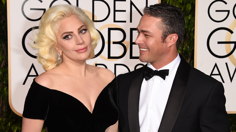 Lady Gaga portant une robe en velours noir et Taylor Kinney en smoking noir et nœud papillon