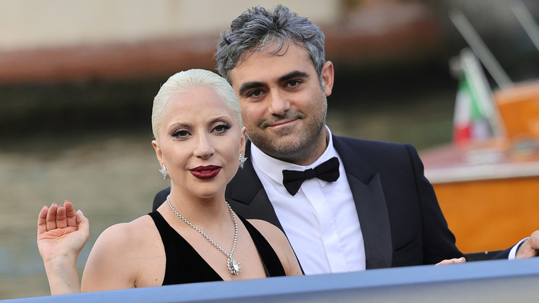 Lady Gaga portant une robe dos nu noire et un collier de diamants avec Michael Polansky portant un smoking noir