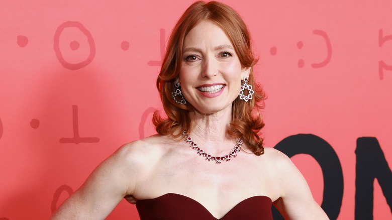 Alicia Witt souriante sur le tapis rouge