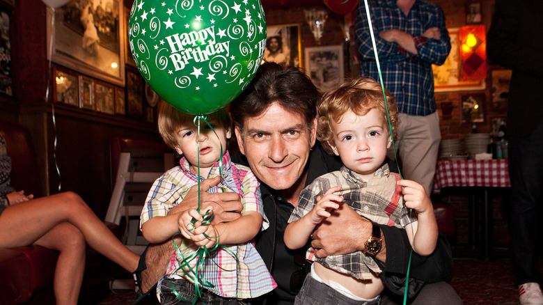 Max, Bob et Charlie Sheen tenant des ballons