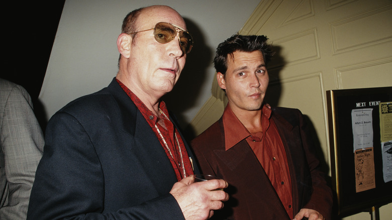 L'auteur Hunter S. Thompson porte une veste noire et une chemise rouge et Johnny Depp porte une veste marron et une chemise orange brûlée.