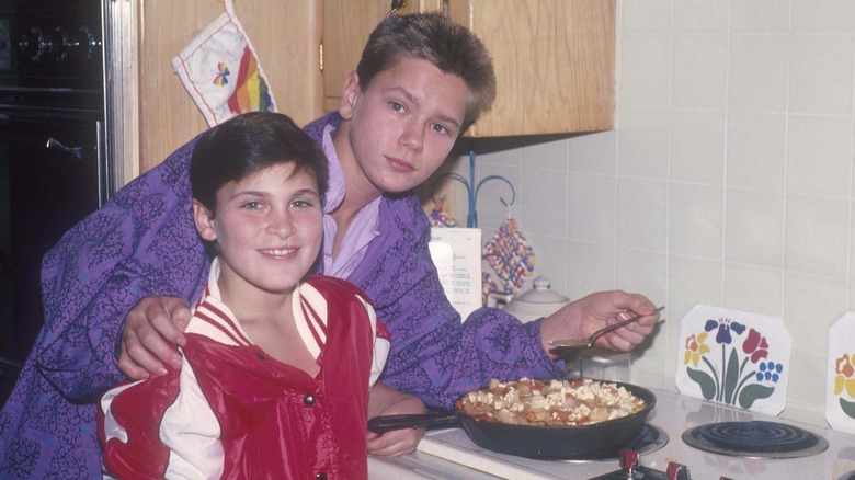 Le jeune Joaquin Phoenix porte une veste rouge et blanche et River Phoenix porte une veste violette