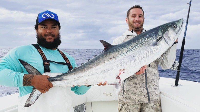 Connor Cruise tenant un poisson