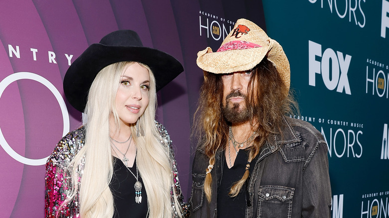 Billy Ray Cyrus pose avec Firerose sur le tapis rouge