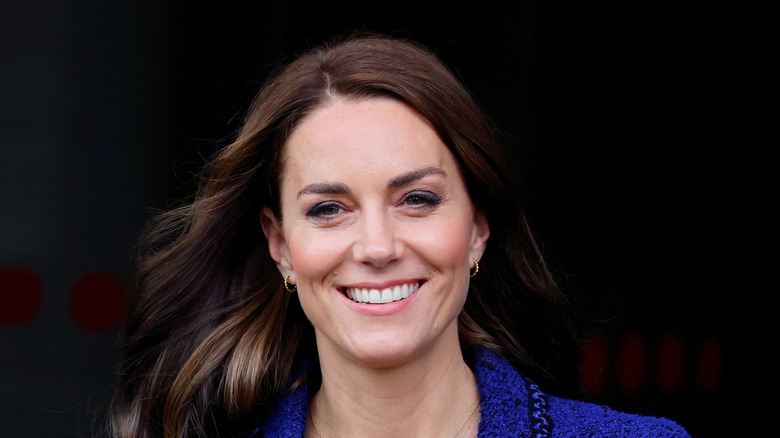 Kate Middleton souriante en costume bleu