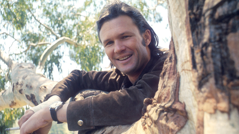 Kris Kristofferson posant contre une branche d'arbre en 1968