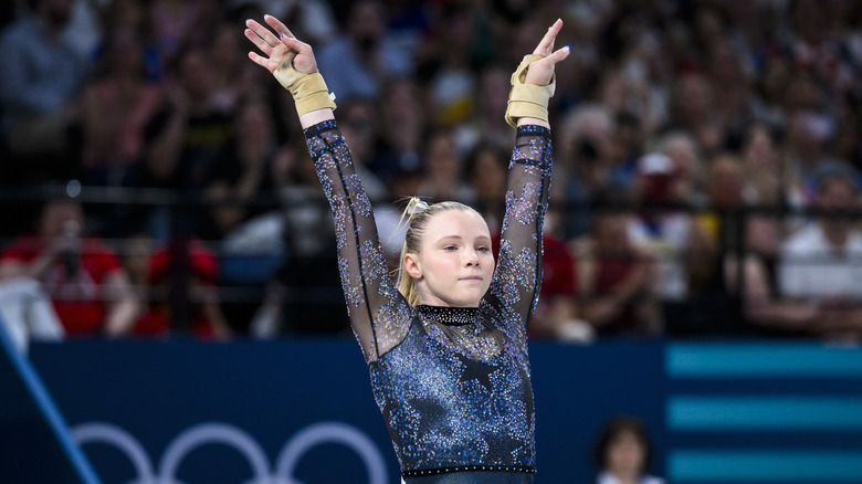 Jade Carey porte des attelles aux poignets et un justaucorps étincelant orné d'étoiles