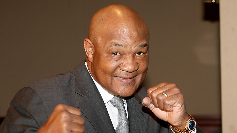 George Foreman souriant, les poings levés