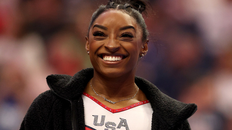 Simone Biles souriante en uniforme américain