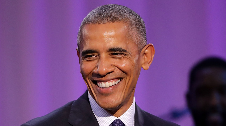 Barack Obama sourit sur fond violet