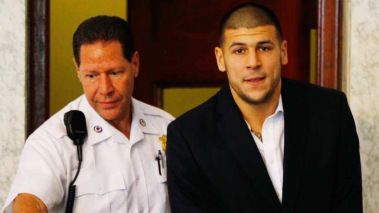 Aaron Hernandez menotté et conduit par un policier