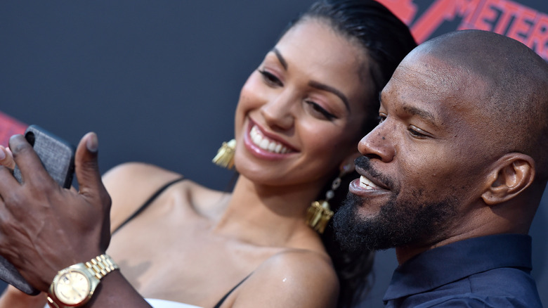 Corinne Foxx et Jamie Foxx regardent leur téléphone