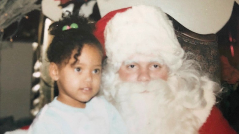 Ayesha Curry enfant, assise sur les genoux du Père Noël