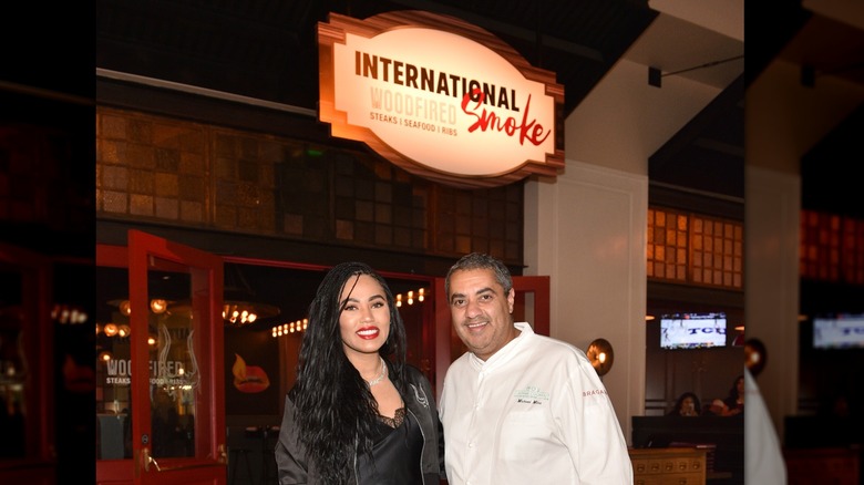 Ayesha Curry et le chef Michael Mina posant dans leur restaurant, International Smoke