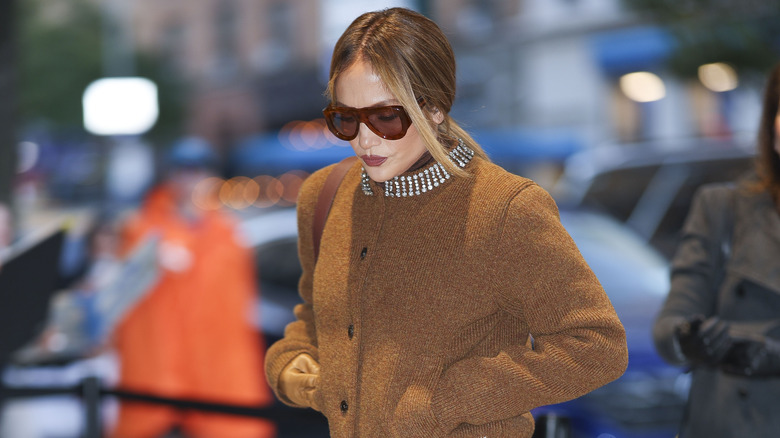 Jennifer Lopez porte des lunettes et une veste marron