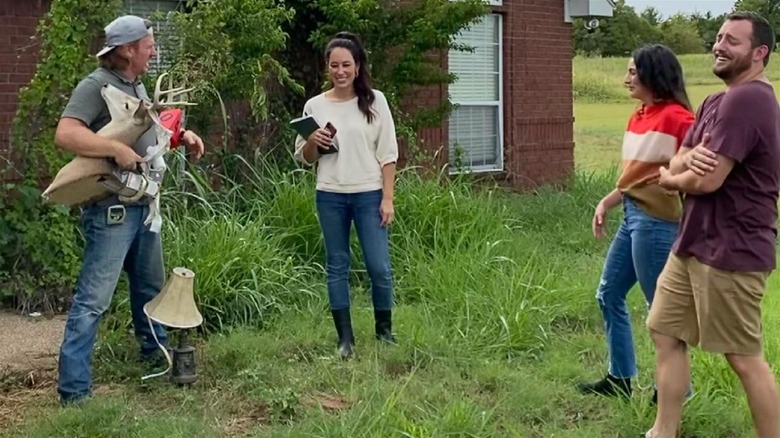 Concurrents de Fixer Upper et acteurs debout dans l'herbe