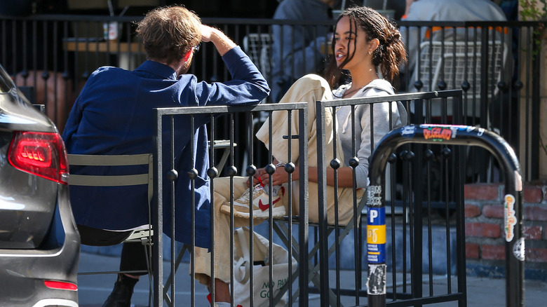 Malia Obama assise avec un pied sur une chaise