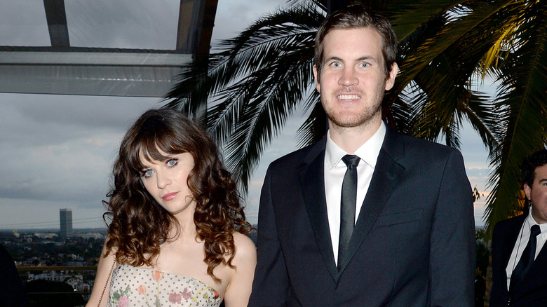 Zooey Deschanel incline la tête à côté de Jamie Linden souriant