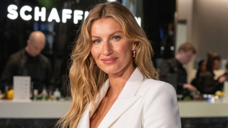 Gisele Bundchen sourit dans un costume blanc