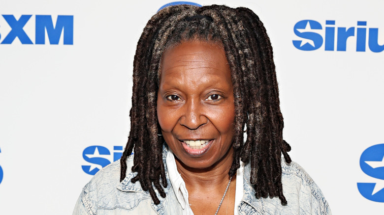 Whoopi Goldberg souriant et portant une veste en jean