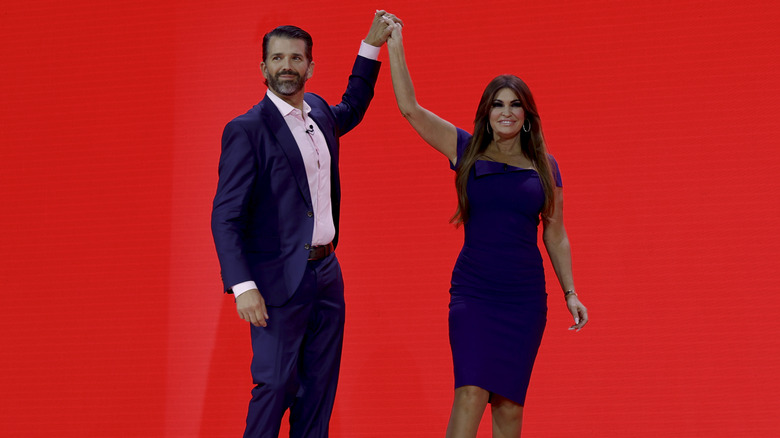 Donald Trump Jr. et Kimberly Guilfoyle se tiennent la main sur scène