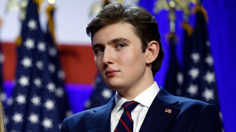 Barron Trump debout devant les drapeaux américains le soir des élections 2024