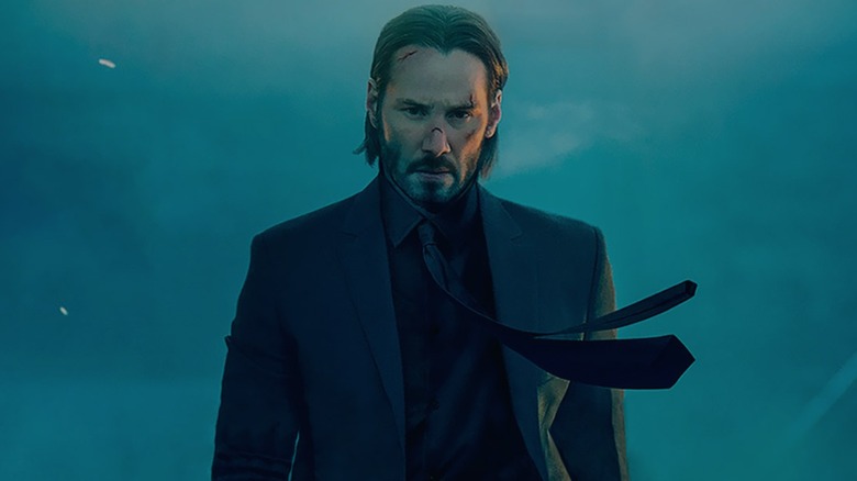 John Wick marchant avec détermination tout en étant armé d'un pistolet silencieux dans John Wick