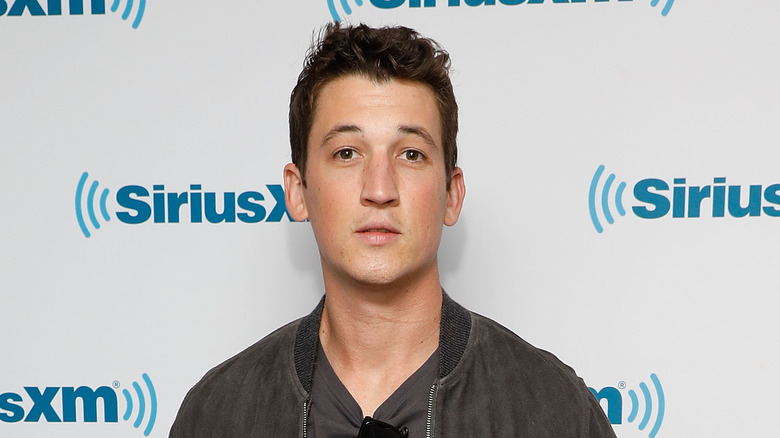 Miles Teller en veste marron