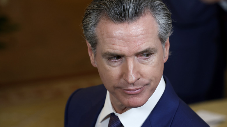 Gavin Newsom regarde par-dessus son épaule lors d'une réunion avec d'autres gouverneurs à la Maison Blanche.