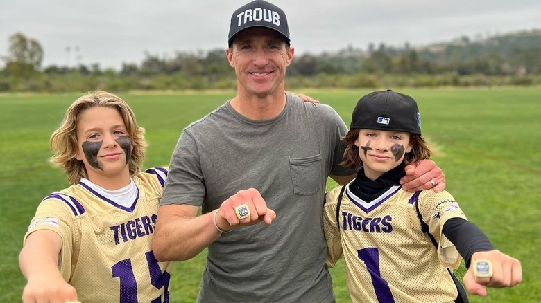 Drew Brees, posant avec ses fils sur un terrain de football