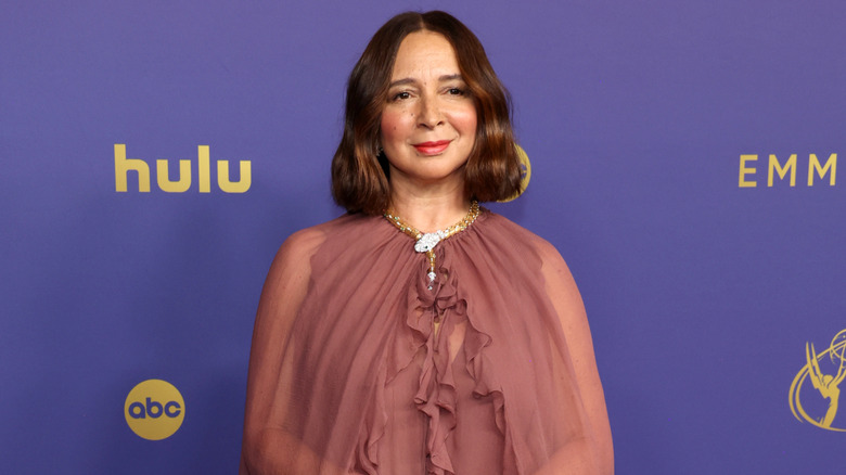 Maya Rudolph portant un collier serpent doré et une robe en mousseline rose poussiéreuse