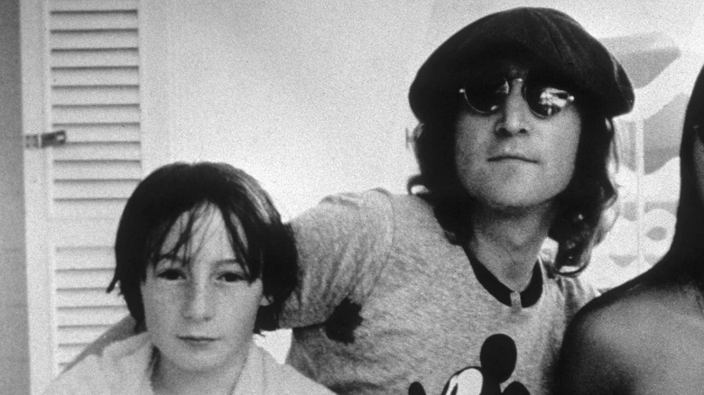 Julian Lennon (à gauche) avec une serviette autour du cou et John Lennon (à droite) portant une chemise Mickey Mouse et une casquette pageboy