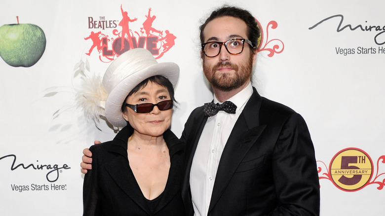 Yoko Ono portant une robe noire et un haut-de-forme blanc avec son fils Sean Ono Lennon portant un smoking noir et un nœud papillon à motifs