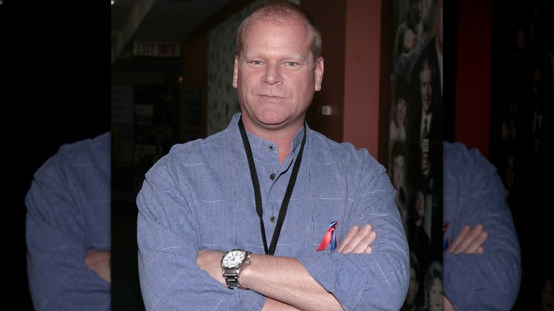 Mike Holmes croise les bras et regarde la caméra.