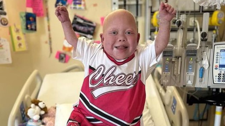 Bella Brave debout et souriante dans un lit d'hôpital