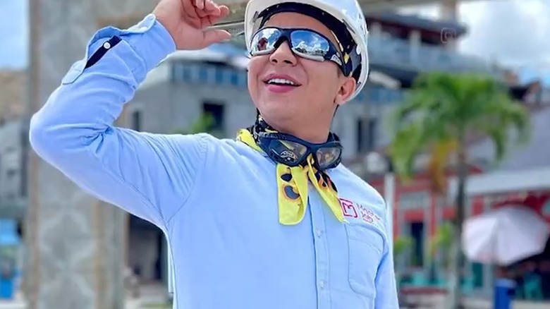 Jainer Moises Pinedo Vargas souriant tout en portant un casque et des lunettes de soleil alors qu'il regarde vers le ciel