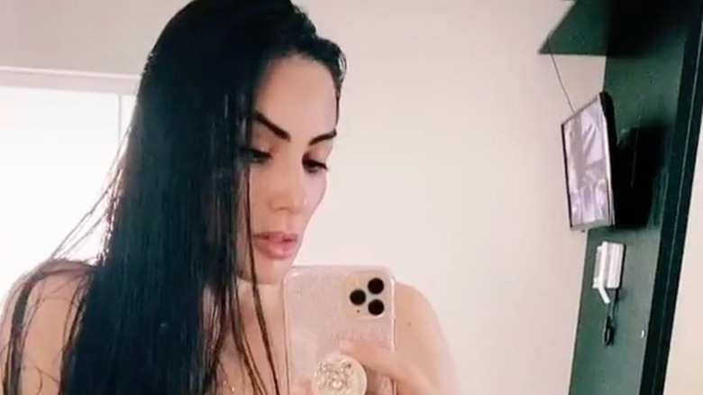 Eliane Ferreira Siolin regarde son téléphone en prenant un selfie