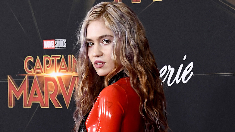 Grimes pose dans une tenue rouge au 