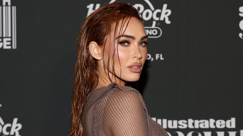 Megan Fox aux longs cheveux roux coiffés avec un look mouillé